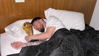 Messi dorme com taça da Copa do Mundo.