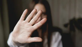 Mulher com a mão estendida sinalizando para parar – a mão dela está no foco