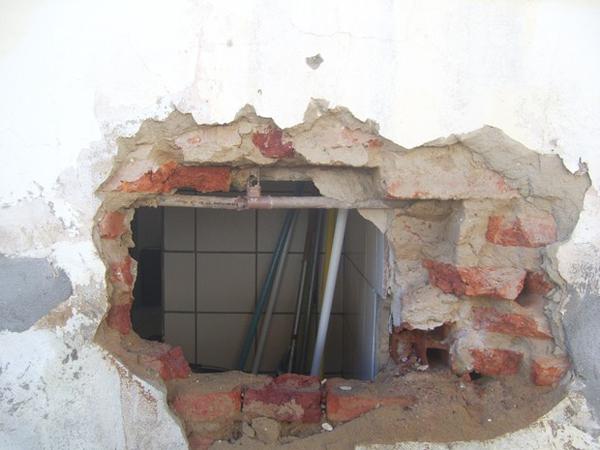 Com uma alavanca, homem abriu buraco na parede da agência para poder entrar(Imagem:Reprodução)