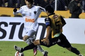 Bernard (E) tenta se desvencilhar da marcação de Méndez, que marcou gol contra