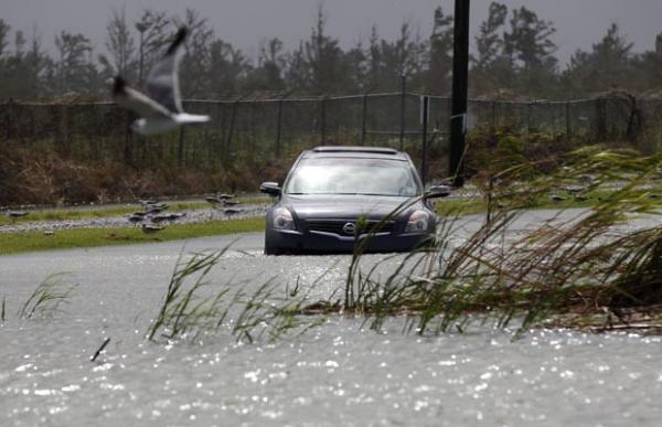 Carro passa em &aacute;rea de Venice, Louisiana, j&aacute; alagada nesta ter&ccedil;a-feira (28) por chuva associadas a Isaac (Imagem:Reprodu&ccedil;&atilde;o)