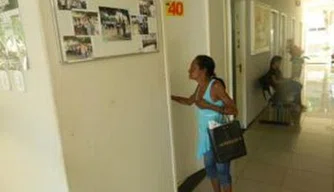 Mulher aguarda atendimento na porta do gabinete mantido por vereador cassado.