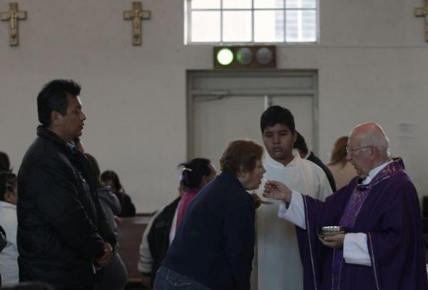Padre cat&oacute;lico distribui a Sagrada Comunh&atilde;o para a congrega&ccedil;&atilde;o como uma luz verde est&aacute; acesa dentro da igreja de Santa Teresa de &Aacute;vila em Monterrey(Imagem:Reprodu&ccedil;&atilde;o)