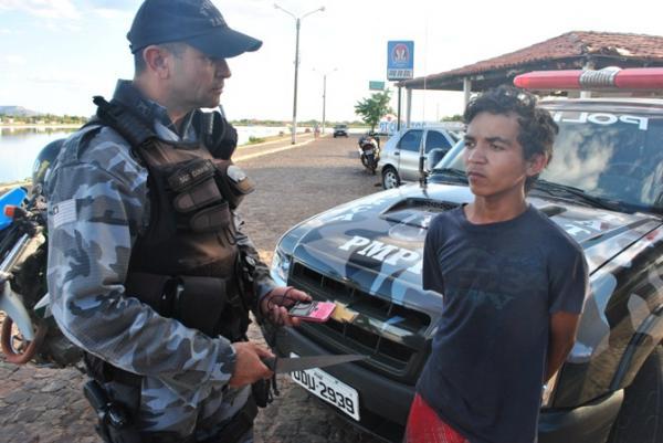 Policial segura objetos apreendidos com acusados(Imagem:Portal Campo Maior)
