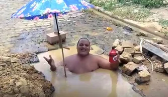 Morador protesta tomando banho dentro de buraco Morador protesta tomando banho dentro de buraco